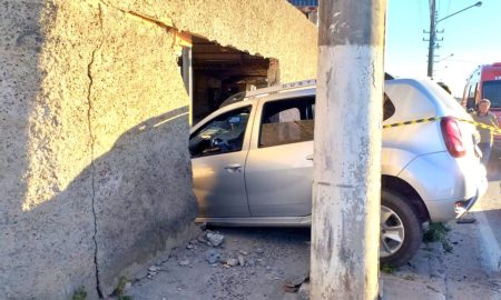 Após colisão, veículo invade muro de empresa