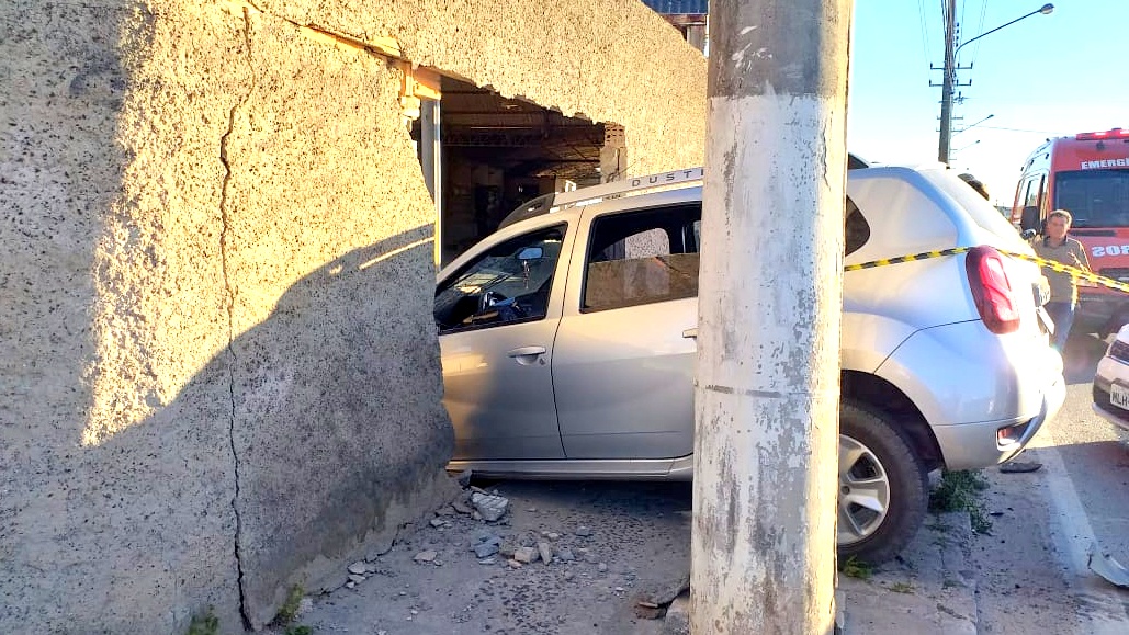 Após colisão, veículo invade muro de empresa